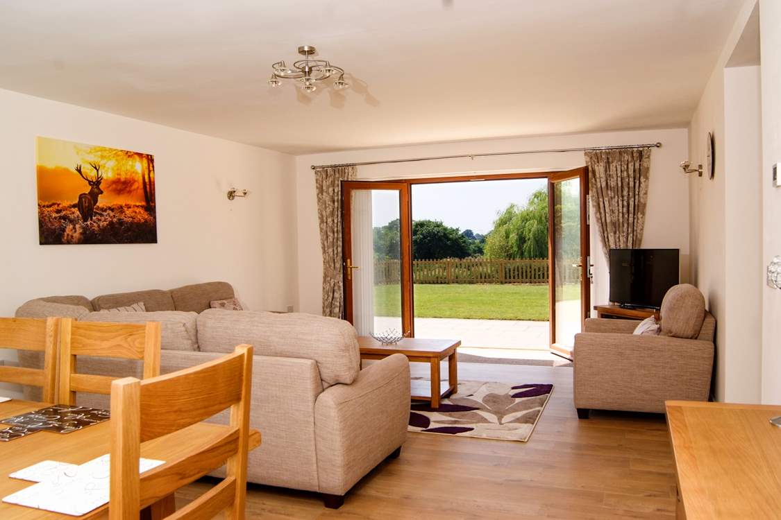 The living/dining room has French windows to the patio and garden and lovely country and lake views
