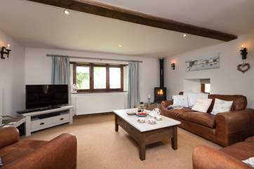 The sitting-room has a wood-burning stove in the corner and plenty of comfortable seating. This is a very spacious room.