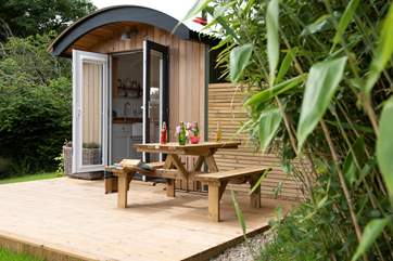 The picnic bench is tucked into the corner of the deck and sheltered.