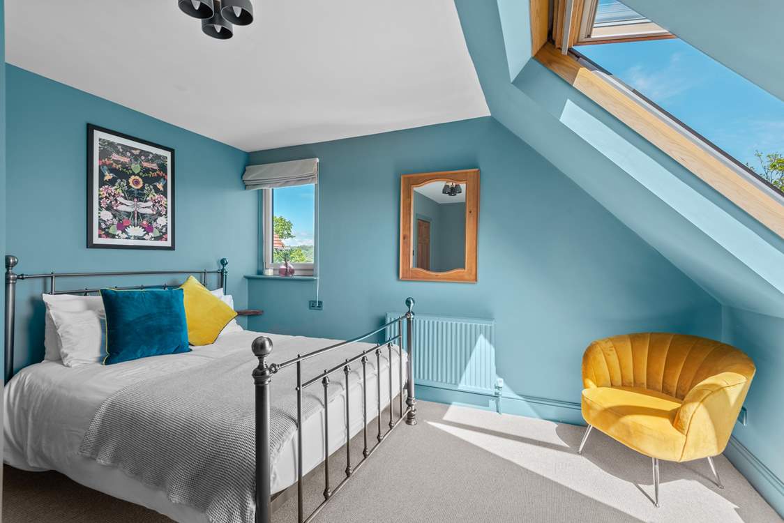 Bedroom 5 has a king-size bed and a view from the Velux window towards the estuary.