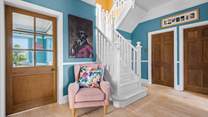 The beautiful stairs lead up from the hallway to the first floor.