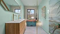 The luxury bathroom is home to a glorious copper roll-top bath and glorious shower cubicle.