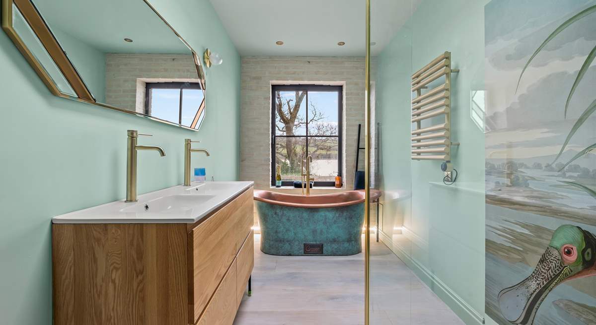 The luxury bathroom is home to a glorious copper roll-top bath and glorious shower cubicle.