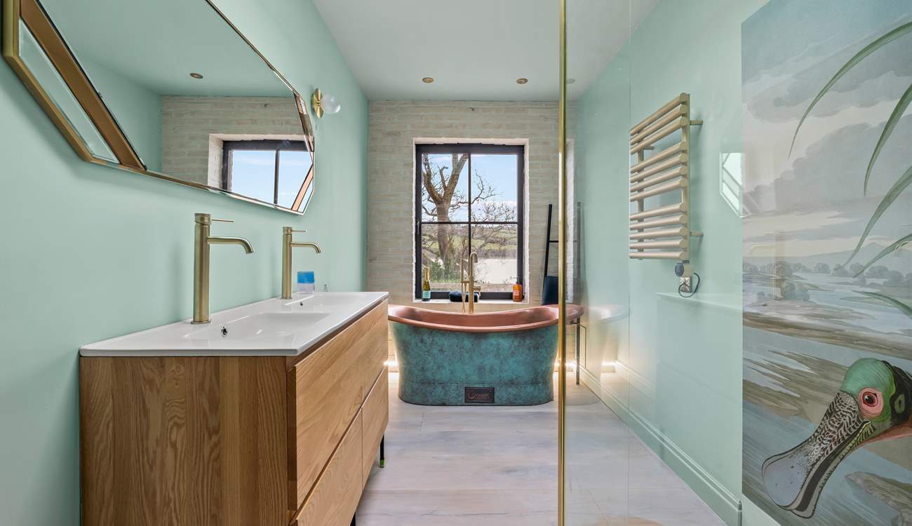 The luxury bathroom is home to a glorious copper roll-top bath and glorious shower cubicle.