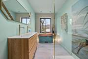 The luxury bathroom is home to a glorious copper roll-top bath and glorious shower cubicle.