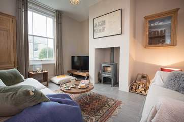 The cosy sitting-room features a wood-burning stove, perfect for the winter months.