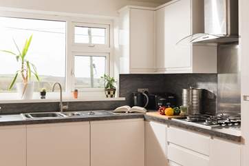 The kitchen is in one corner of the open plan living space and is well-equipped. The window looks out onto the rear terrace, and has sea views.
