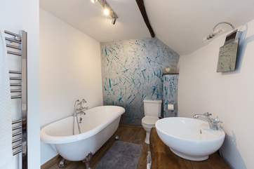The en suite bathroom is fabulous, with its roll-top bath, hand-made basin surround and hand designed feature wall!