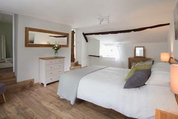 The en suite bathroom is up the steps to the right and to the left, also up some steps, is a cot room or dressing-room.