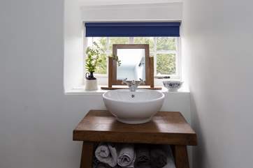 There is a stylish bespoke basin surround.