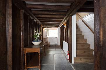 This is the original cross-passage with its historic panelling. A stable-door takes you out to the back garden. There is a cloakroom to the right and then the wooden stairs to the first floor.