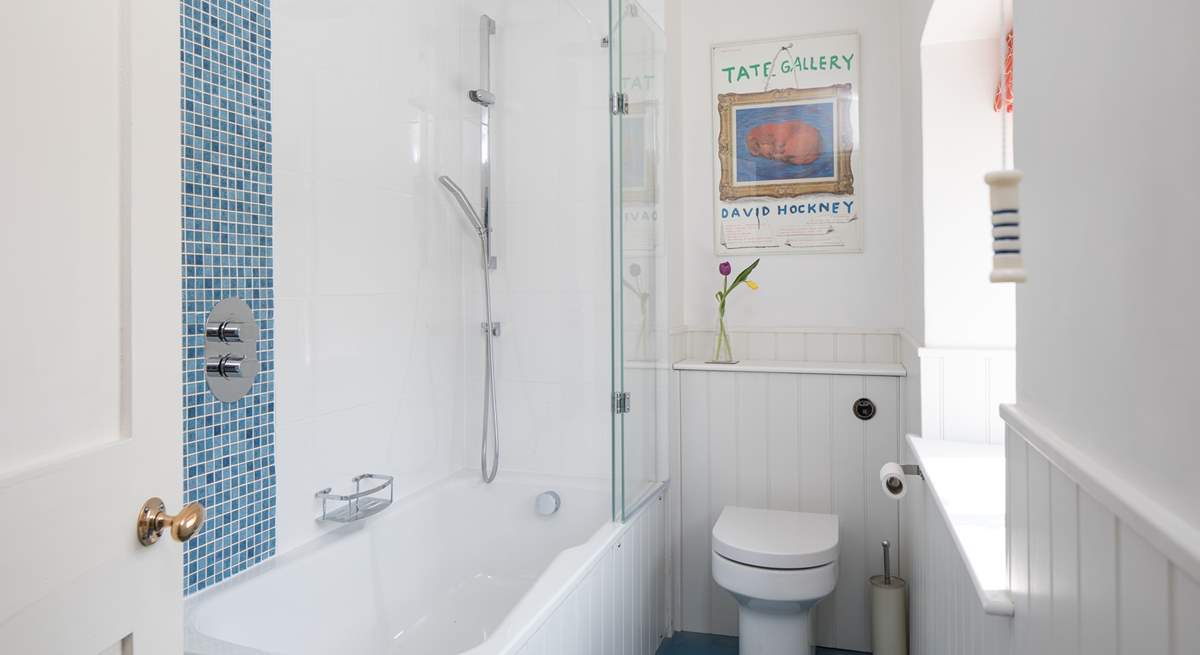 A bath and shower in this bright family bathroom.