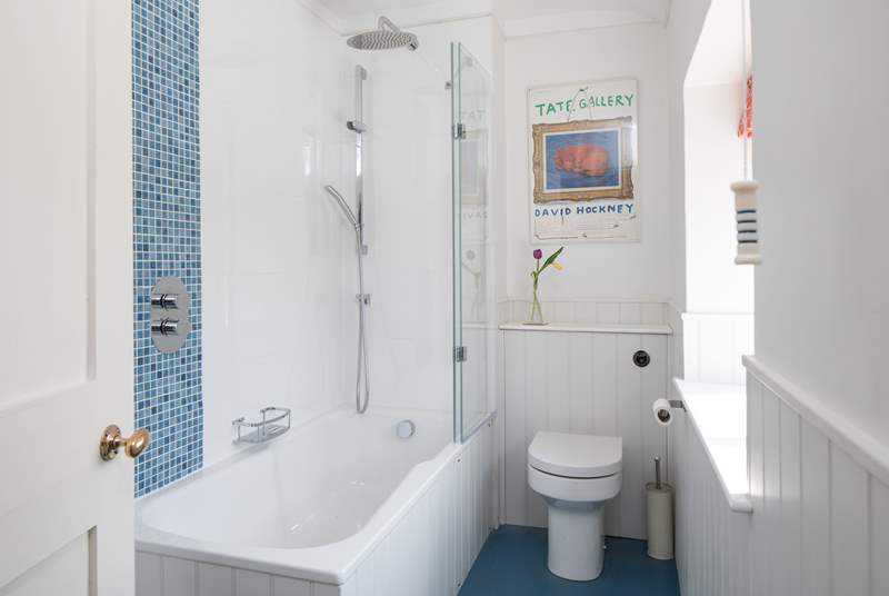 A bath and shower in this bright family bathroom.