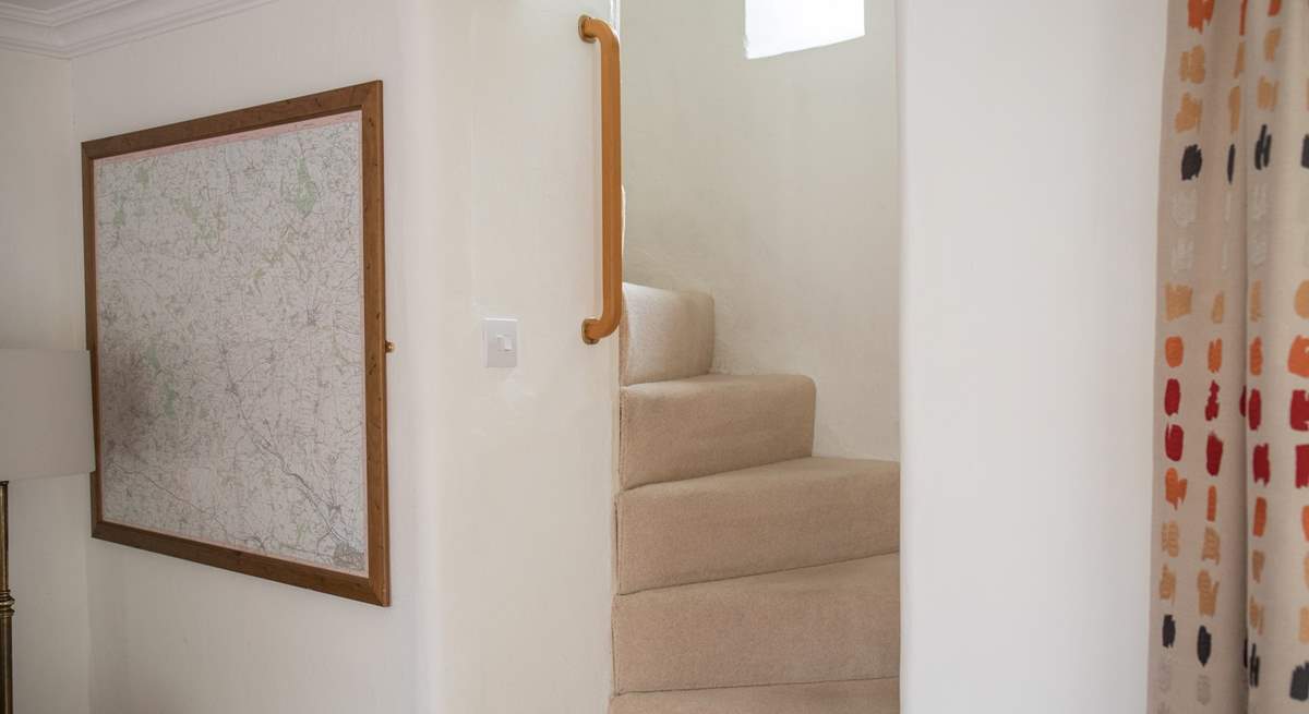 The turning cottage stairs are a delightful feature in this listed cottage, there are grab rails all the way up.