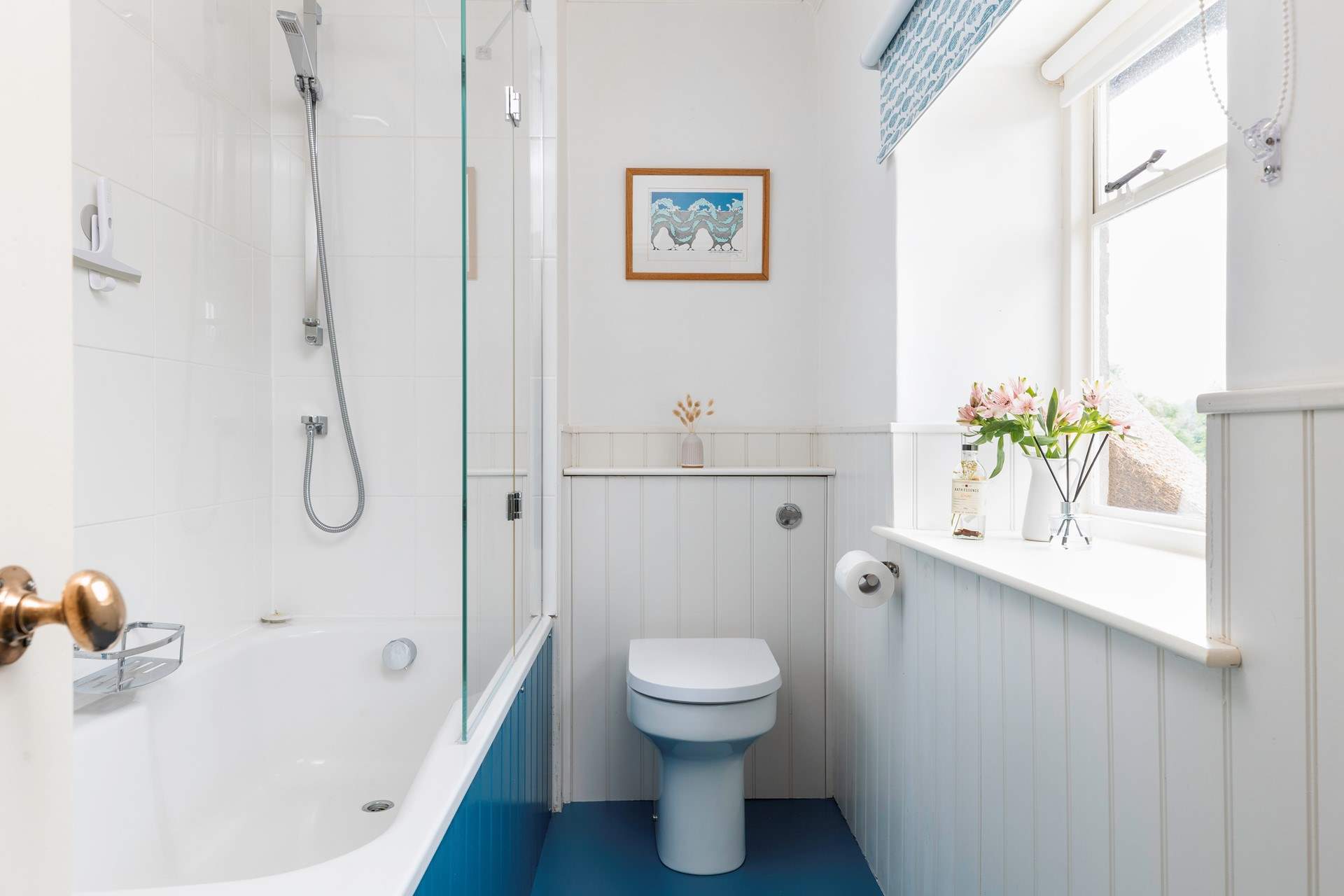A bath and shower in this bright family bathroom.