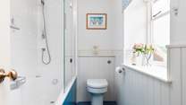A bath and shower in this bright family bathroom.