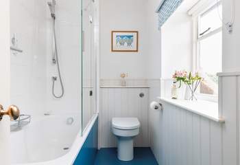 A bath and shower in this bright family bathroom.