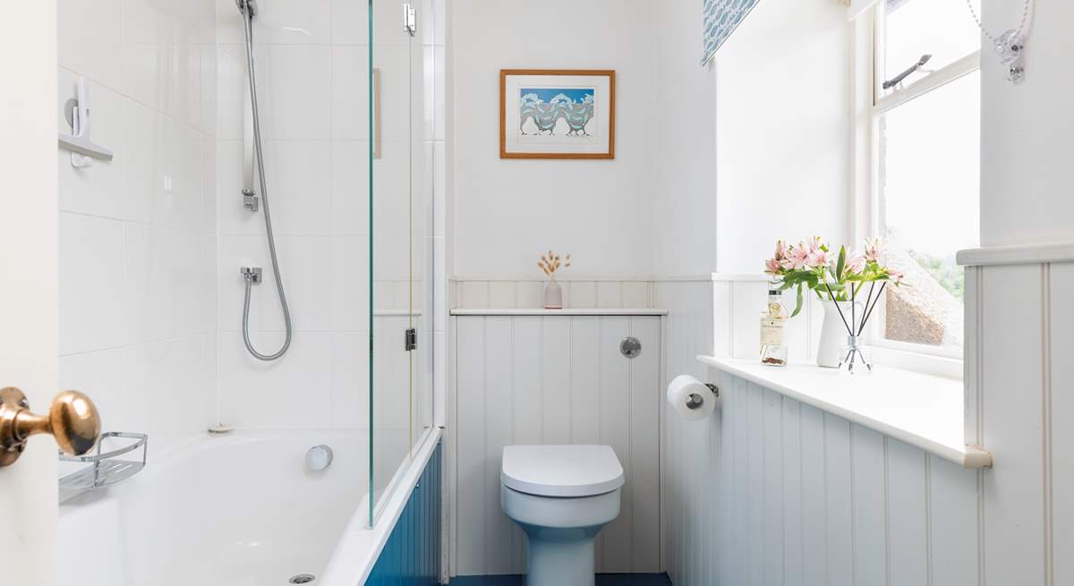 A bath and shower in this bright family bathroom.