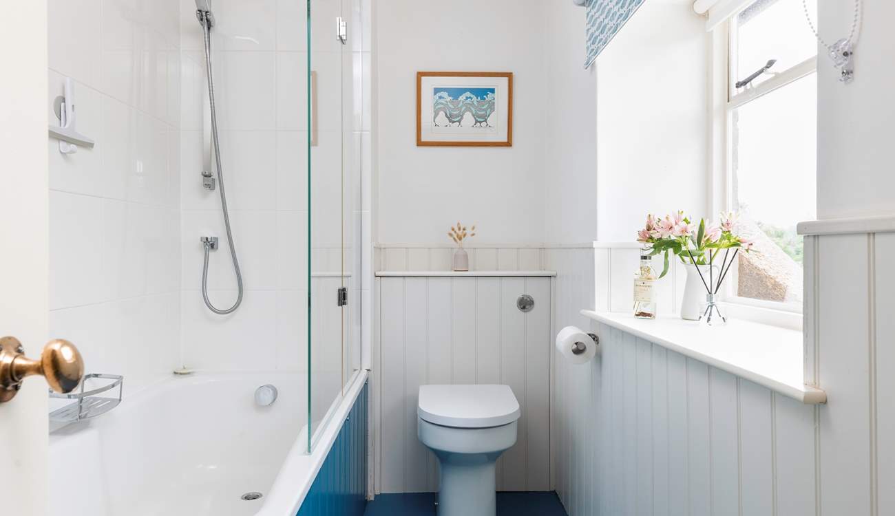 A bath and shower in this bright family bathroom.