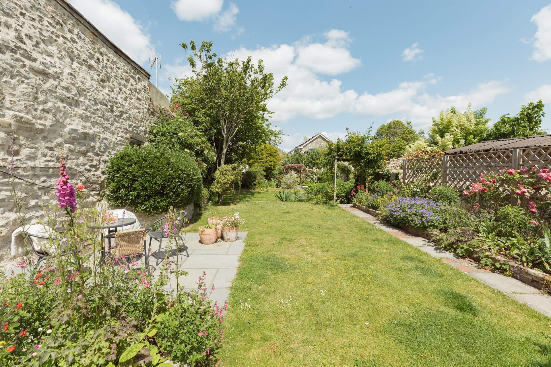 Up from the lower patio the carefully landscaped garden runs off into the distance...