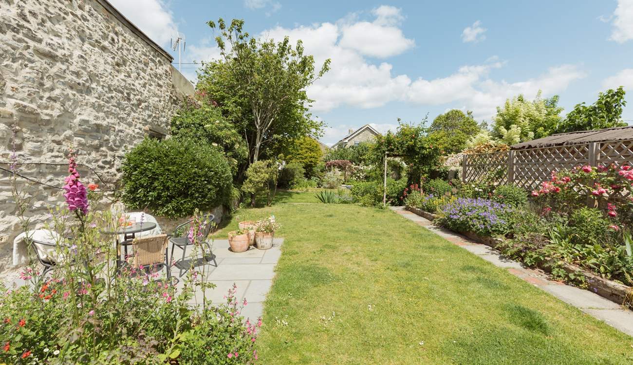 Up from the lower patio the carefully landscaped garden runs off into the distance...