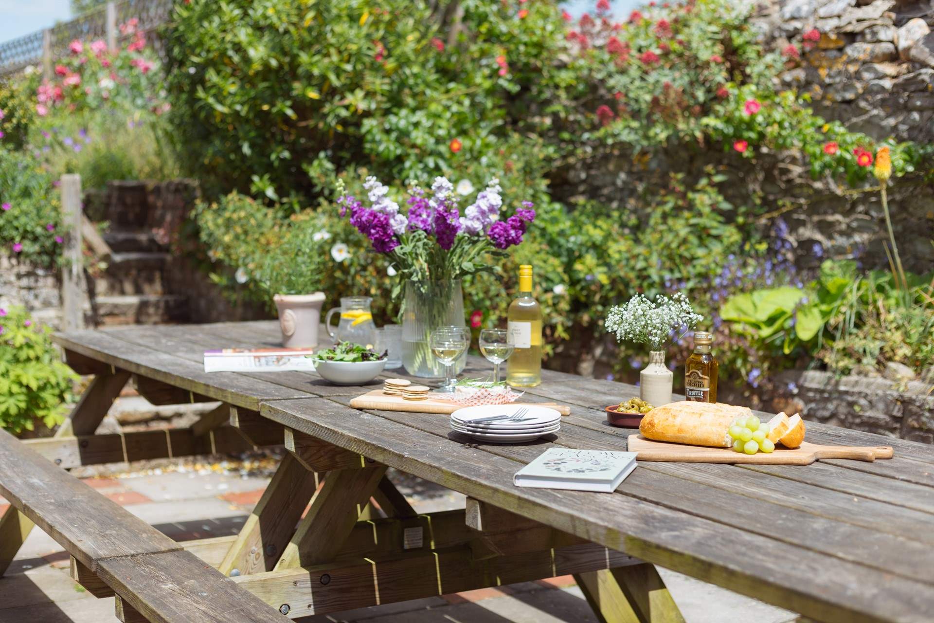 The patio off the kitchen is home to a huge outdoor dining area and surrounded by stunning colour and greenery