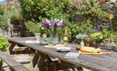The patio off the kitchen is home to a huge outdoor dining area and surrounded by stunning colour and greenery - Thumbnail Image