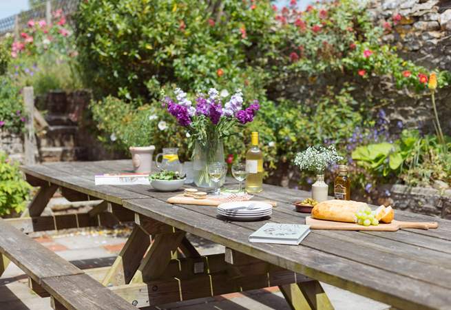 The patio off the kitchen is home to a huge outdoor dining area and surrounded by stunning colour and greenery