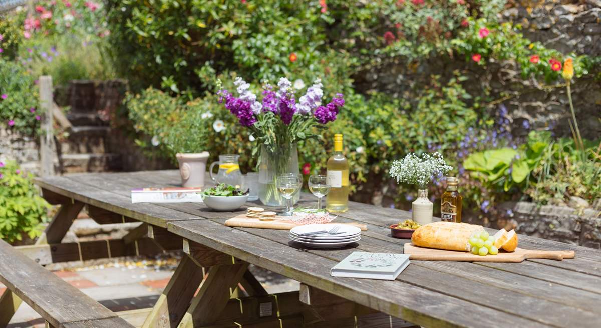 The patio off the kitchen is home to a huge outdoor dining area and surrounded by stunning colour and greenery