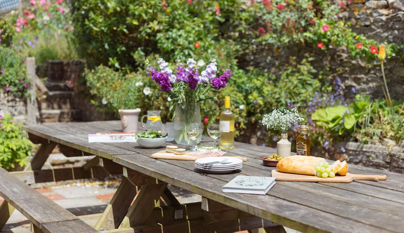 The patio off the kitchen is home to a huge outdoor dining area and surrounded by stunning colour and greenery