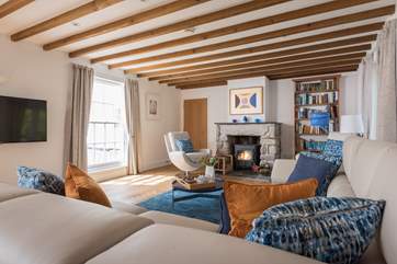 Relax in front of the wood-burner in this light and airy sitting-room.