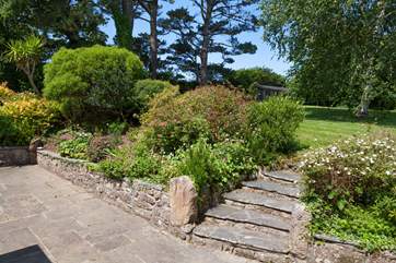 The borders are jam packed with colourful shrubs and the mature trees provide shade when the sun is beating down.