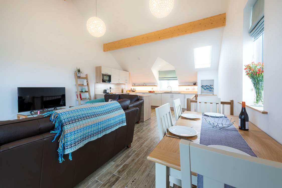 The open plan living area with the dining-table to the right of the picture.