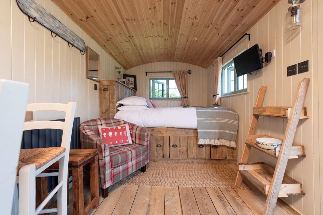 The Hypnos king-size bed offers a blissful night's sleep. With two windows looking out over the meadow, ponds and countryside beyond.