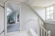 The stairs wind up from the ground floor, through the first floor and deliver you on the hallway on the second floor.