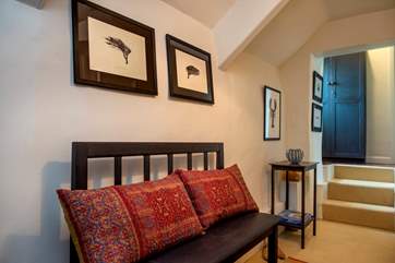 In the upstairs hallway, 3 steps lead up to the bathroom and one of the double bedrooms.