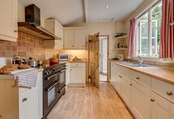 The kitchen/dining-room has a large range cooker. Beyond the kitchen is a utility-room and the back door to the garden.