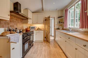 The kitchen/dining-room has a large range cooker. Beyond the kitchen is a utility-room and the back door to the garden.