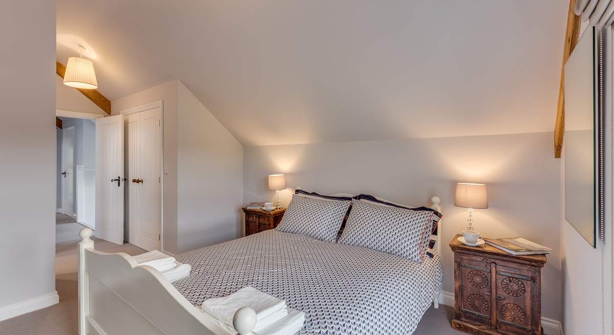 The main bedroom has a king-size bed and its own en suite shower-room. High ceilings and a large window make this room lovely and light and airy.