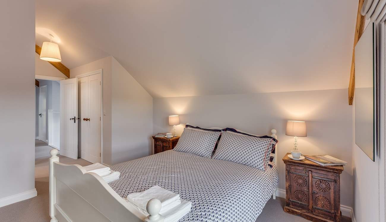 The main bedroom has a king-size bed and its own en suite shower-room. High ceilings and a large window make this room lovely and light and airy.