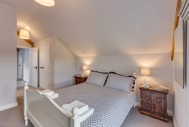 The main bedroom has a king-size bed and its own en suite shower-room. High ceilings and a large window make this room lovely and light and airy.