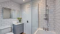 The bathroom next to the twin bedroom has a bath as well as a fitted shower.
