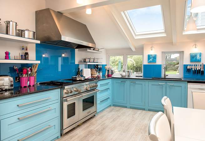 The bespoke kitchen has wonderful bright blue units and a fabulous range cooker - ideal when cooking for a crowd.