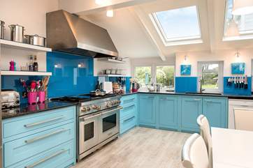 The bespoke kitchen has wonderful bright blue units and a fabulous range cooker - ideal when cooking for a crowd.