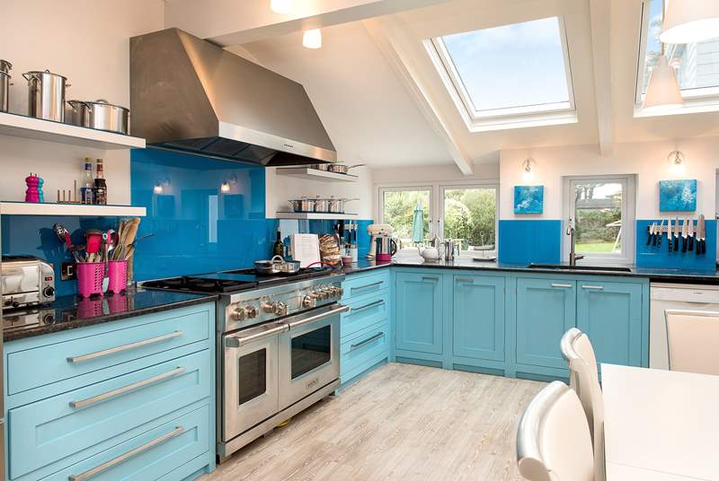 The bespoke kitchen has wonderful bright blue units and a fabulous range cooker - ideal when cooking for a crowd.