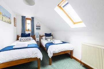Bedroom three floods with light offering twin beds.