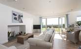 A comfortable deep sofa in open plan living area with glorious sea views. - Thumbnail Image