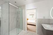 The beautiful en suite in bedroom 1 has stunning marble tiling.
