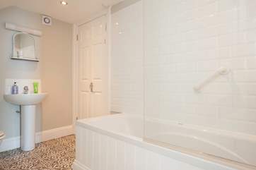The spacious family bathroom with bath and shower over