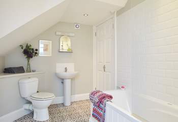 The spacious family bathroom with bath and shower over.